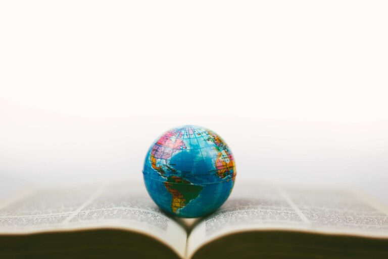 Globo terráqueo vintage con enfoque suave, Biblia abierta y lupa.,
